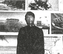 A grainy black and white photograph of artist mario lemafa standing in front of a video projection of a google image search